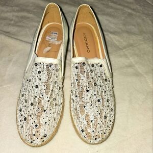Pair of cream colored bling slip on shoes